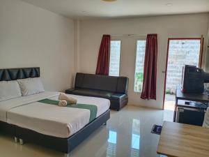 1 dormitorio con 1 cama y 1 sofá en Tom's house, en Khura Buri