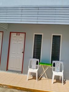 dos sillas y una mesa frente a un edificio en Tom's house, en Khura Buri