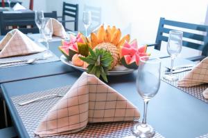 a table with a plate of fruit and a bowl of flowers at Chami Villa Bentota in Bentota