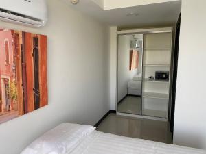ein Schlafzimmer mit einem weißen Bett und einem Spiegel in der Unterkunft AYA APARTMENTS IN MBC in Mai Khao Beach + 57 Fotos