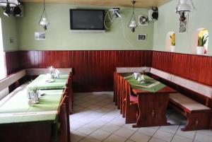 a restaurant with two tables and a television on the wall at Penzion Haus Regrus in Jáchymov