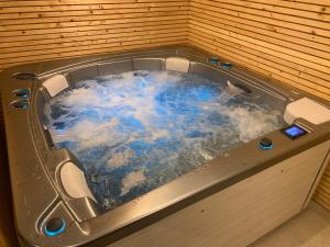 uma banheira de hidromassagem com água azul em Durbuy House le Noyer em Durbuy