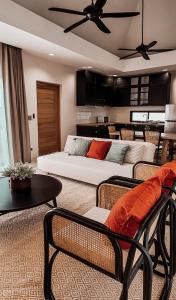 Pranatarn Pool Villa Mid-Summer Night في Ban Bo Kaeo: غرفة معيشة مع سرير وطاولة وكراسي