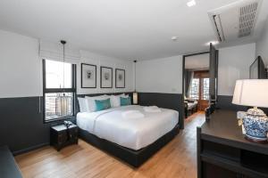 a bedroom with a large white bed and some windows at The Lantern Hatyai Hotel in Hat Yai