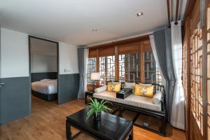 The Lantern Hatyai Hotel في هات ياي: غرفة معيشة مع أريكة وسرير