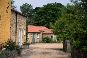 a group of brick buildings with trees in the background at Alwent Mill in Winston