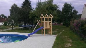 a playground with a slide next to a pool at Ubytování Macků in Spolí