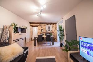 ein Wohnzimmer mit einer Küche und einem Esszimmer in der Unterkunft LA MADELEINE -GARE - CENTRE-VILLE - Home-One in Saint-Vit