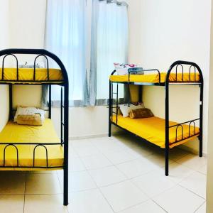two bunk beds in a room with a window at LADIES ONLY-AnaRuby Backpackers - Metro Station Mashreq in Dubai