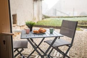 einen Tisch mit einem Teller Essen und zwei Stühlen in der Unterkunft LA MADELEINE -GARE - CENTRE-VILLE - Home-One in Saint-Vit