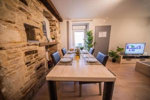 a long table in a room with a stone wall at LA MADELEINE -GARE - CENTRE-VILLE - Home-One in Saint-Vit