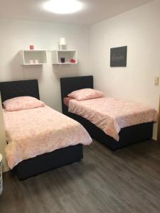 um quarto com duas camas com lençóis cor-de-rosa em FEWO Eggenstein beim KIT em Eggenstein-Leopoldshafen