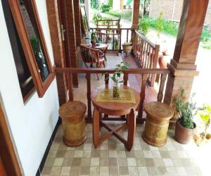 einen Balkon mit einem Tisch und Stühlen auf einer Veranda in der Unterkunft Borobudur Cluster Homestay Candirejo Syariah in Tanayung