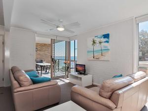 een woonkamer met 2 banken en een televisie bij Shoreline, 4,7 Victoria Parade - Views over Fly Point and close to Nelson Bay Marina in Nelson Bay