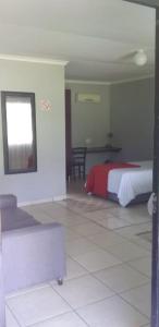 1 dormitorio con 1 cama y 1 sofá en una habitación en Mbazwana Inn en Mbazwana