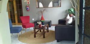 un soggiorno con divano, tavolo e sedie di Mbazwana Inn a MʼBazwane