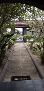 una pasarela en un jardín con árboles y un edificio en Mbazwana Inn en Mbazwana