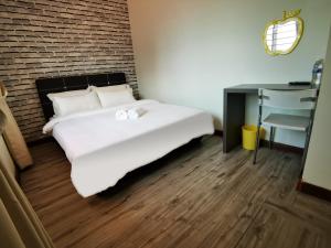 uma cama branca num quarto com uma secretária e uma cadeira em Double Storey Linked To KPJ Medical Specialist Centre Bdc 10BR By Natol Homestay-Paris em Kuching