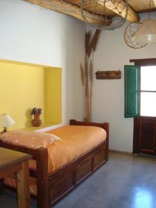 1 dormitorio con 1 cama en una habitación con paredes amarillas en Lo de Lili en Tilcara