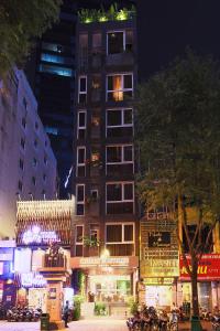 un grand bâtiment avec un magasin dans une ville la nuit dans l'établissement CHERRY BOUTIQUE HOTEL, à Hô-Chi-Minh-Ville