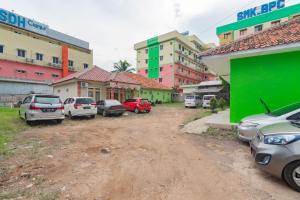 eine Gruppe von Autos, die vor den Gebäuden geparkt werden in der Unterkunft RedDoorz near Tugu Pramuka Cianjur in Bojong 1