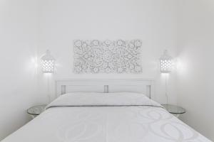 a white bedroom with a white bed and two lamps at Andrew'S home - Playita in Torre Pali