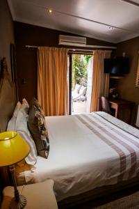 A bed or beds in a room at Town and Country Mpumalanga