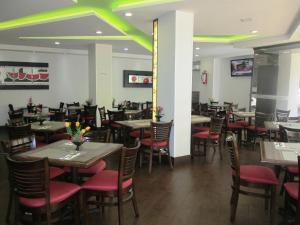 a dining room with tables and red chairs at Hotel Premier in Mexico City