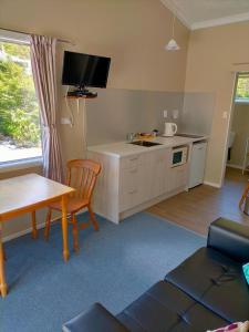 a living room with a kitchen with a sink and a table at Arthur's Pass Alpine Motel in Arthur's Pass