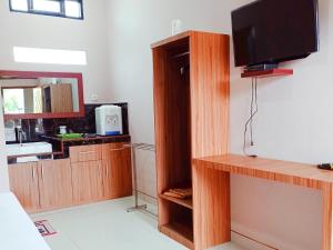 TesにあるRedDoorz Syariah Near Danau Tes Bengkuluのリビングルーム(テレビ付)、キッチン