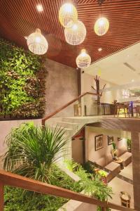 a lobby with a staircase with plants and lights at CHERRY BOUTIQUE HOTEL in Ho Chi Minh City