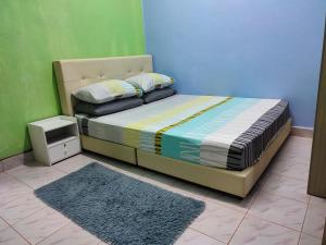 una camera da letto con un letto con una parete blu e verde di Homestay Tepi Sungai Golok a Rantau Panjang