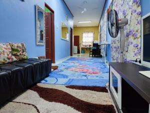 uma sala de estar com um sofá e uma parede azul em Riverview Homestay - Homestay Tepi Sungai Golok em Rantau Panjang