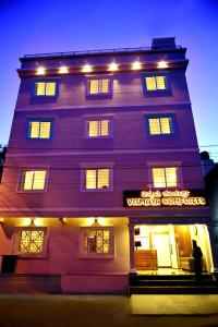 a purple building with lights on top of it at Vismaya Comforts in Mysore