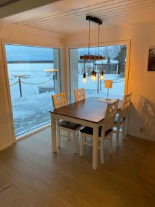 a dining room with a table and chairs and a window at Villa Muikkupolku in Kokkola