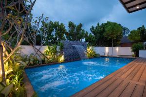 a swimming pool in a backyard with a water fountain at Alivila in Muar