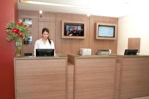 a woman sitting at a counter in an office at Hotel Jangadeiro in Recife +37 photos