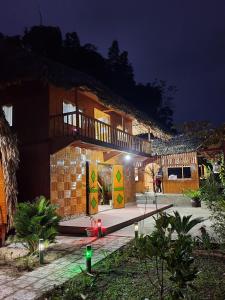 - un bâtiment avec des portes colorées la nuit dans l'établissement Homestay Khoáng nóng Thông Nguyên, à Nam Giang