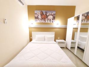 Un pequeño dormitorio con una cama blanca y estanterías en Rons City Hotel near Simpang Lima Semarang Mitra RedDoorz en Semarang