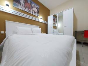 Rúm í herbergi á Rons City Hotel near Simpang Lima Semarang Mitra RedDoorz