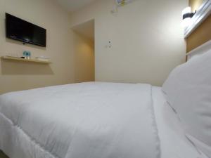 Rúm í herbergi á Rons City Hotel near Simpang Lima Semarang Mitra RedDoorz