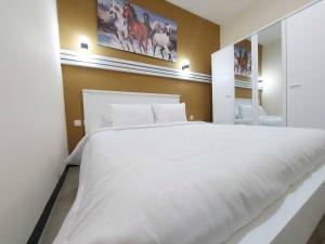 Rúm í herbergi á Rons City Hotel near Simpang Lima Semarang Mitra RedDoorz