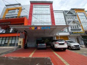 un estacionamiento con autos estacionados frente a un edificio en Rons City Hotel near Simpang Lima Semarang Mitra RedDoorz en Semarang
