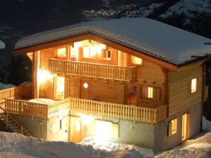 une cabane en rondins dans la neige la nuit dans l'établissement Luxury Chalet with Jacuzzi in La Tzoumaz, à La Tzoumaz