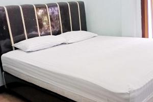 迪昂Homestay Dieng Persada Syariah Mitra RedDoorz的一张床，上面有两个枕头