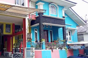 a colorful house on the side of a street at Homestay Dieng Persada Syariah Mitra RedDoorz in Dieng