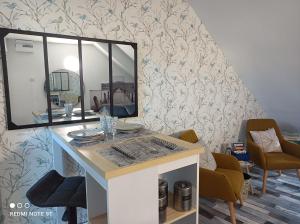 um quarto com uma secretária com um espelho e cadeiras em Très beau studio Climatisation, Trois Etoiles, WiFi, Vélos en option, Parking Privé Jardin em Montargis