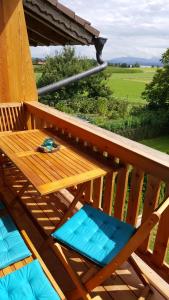 una mesa de madera y sillas en una terraza en Ferienwohnung ChiemseeZeit :-) - Familie Lechermann en Gstadt am Chiemsee