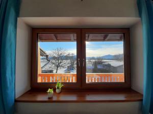 una ventana en una habitación con vistas a la nieve en Ferienwohnung ChiemseeZeit :-) - Familie Lechermann en Gstadt am Chiemsee