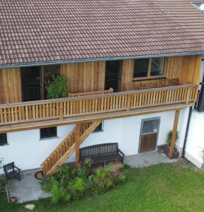 una terrazza in legno sul lato di una casa di Ferienwohnung ChiemseeZeit :-) - Familie Lechermann a Gstadt am Chiemsee